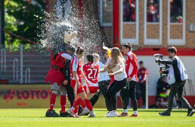 Fussball, Frauen, Saison 2024 2025, 2. Bundesliga (23. Spieltag), 1. FC Union Berlin - Borussia Mönchengladbach, Union feiert den Aufstieg in die 1. Bundesliga, Bierdusche für Trainerin Ailien Poese (1. FC Union) und Maskottchen Ritter Keule, 27.04.2025, Copyright: xSebastianxRäppold MatthiasxKochx