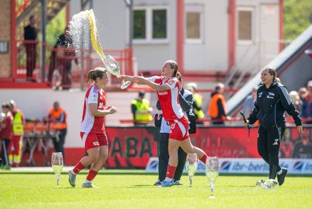 Fussball, Frauen, Saison 2024 2025, 2. Bundesliga (23. Spieltag), 1. FC Union Berlin - Borussia Mönchengladbach, Union feiert den Aufstieg in die 1. Bundesliga, v.l. Dina Orschmann (1. FC Union), Charleen Niesler (1. FC Union) verteilt Bierduschen, 27.04.2025, Copyright: xSebastianxRäppold MatthiasxKochx
