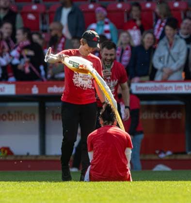 Fussball, Frauen, Saison 2024 2025, 2. Bundesliga (23. Spieltag), 1. FC Union Berlin - Borussia Mönchengladbach, Union feiert den Aufstieg in die 1. Bundesliga, v.l. Trainerin Ailien Poese (1. FC Union) verteilt eine Bierdusche an Eleni Markou (1. FC Union), 27.04.2025, Copyright: xSebastianxRäppold MatthiasxKochx