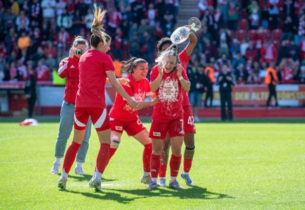 Fussball, Frauen, Saison 2024 2025, 2. Bundesliga (23. Spieltag), 1. FC Union Berlin - Borussia Mönchengladbach, Union feiert den Aufstieg in die 1. Bundesliga, v.l. Nele Bauereisen (1. FC Union), Korina Janez (1. FC Union) und Naika Reissner (1. FC Union) verteilen Bierdusche an Lisa Heiseler (1. FC Union), 27.04.2025, Copyright: xSebastianxRäppold MatthiasxKochx