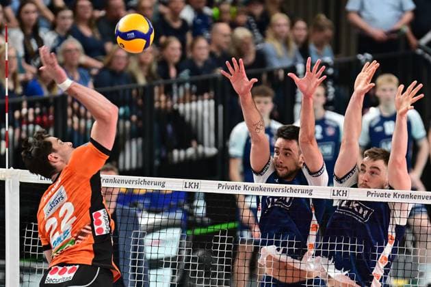 Volleyball I Herren I Saison 2024-2025 I Bundesliga I Finale I Spiel 2 I SVG Lüneburg - BERLIN RECYCLING Volleys I 1.5.2025 Jake Hanes (22, Berlin Recycling Volleys) tritt gegen den Doppelblock von Xander Wolf Wassenaar Ketrzynski (11, SVG Lüneburg) und Simon Torwie (1, SVG Lüneburg) an Lüneburg LKH Arena Niedersachsen Deutschland Copyright: xLobeca AndreasxHannigx