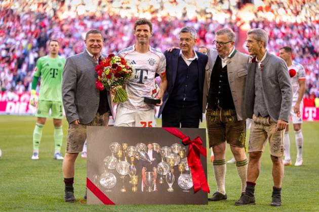 10.05.2025, Fussball 1. Bundesliga 2024 2025, 33. Spieltag, FC Bayern München - Borussia Mönchengladbach, in der Allianz-Arena München. Thomas Müller (FC Bayern München) bekommt Blumen und ein Foto mit allen gewonnenen Trophäen zu seiner Verabschiedung. v.li: Sportvorstand Max Eberl (Bayern München), Thomas Müller (FC Bayern München), Präsident Herbert Hainer (FC Bayern), Vorstandsvorsitzender Jan-Christian Dreesen (FC Bayern München), Geschäftsführer Michael Diederich (FC Bayern München) alle in Lederhosen.
