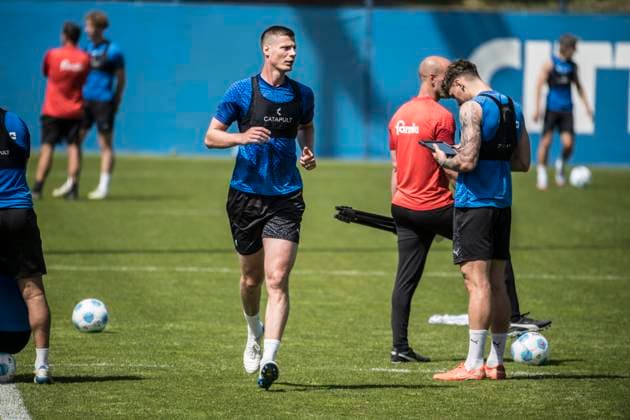 14.05.2025, Fußball, Herren, 1.BL, Saison 2024 2025, Training Holstein Kiel Patrick Erras freht seine Runde, Nicolai Remberg prüft seine Daten auf dem Tablett Kiel, Projensdorf Projensdorf, Trainigsplatz, Kuns Schleswig-Holstein Deutschland *** 14 05 2025, Football, Men, 1 BL, Season 2024 2025, Training Holstein Kiel Patrick Erras frees his lap, Nicolai Remberg checks his data on the tablet Kiel, Projensdorf Projensdorf, Training ground, Kuns Schleswig Holstein Germany