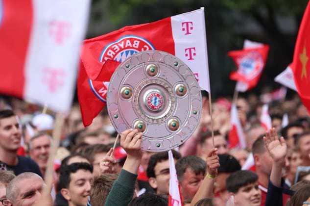 Fussball, Herren, Bundesliga, Saison 2024 2025, FC Bayern München, Meisterfeier, Rathausbalkon, Marienplatz Stimmung auf dem Marienplatz, voll mit Fans des FC Bayern München, hier eine Nachbildung der Meisterschale bei einem Fan