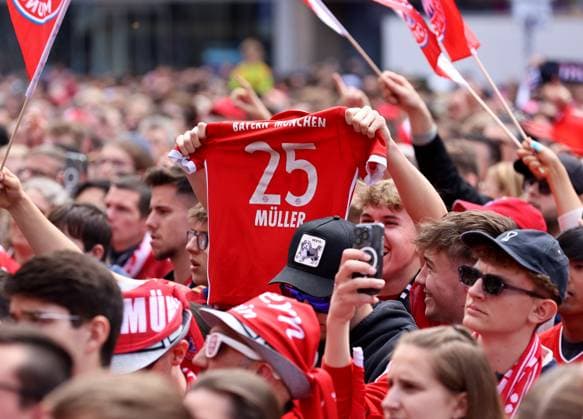 Fussball, Herren, Bundesliga, Saison 2024 2025, FC Bayern München, Meisterfeier, Rathausbalkon, Marienplatz Ein Fan streckt ein Trikot von Thomas Müller, Mueller (FC Bayern München) in die Höhe