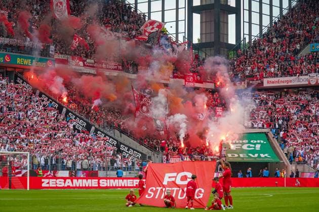 oh18.05.2025 - Deutschland: 2. Fussball Bundesliga 2024 2025, 34. Spieltag - 1. FC Köln vs. 1. FC Kaiserslautern - Rhein-Energie-Stadion (Köln): Gästeblock der Fans aus Kaiserslautern zündeln Bengalo, Fackeln, Rauch, Feuer, davor auf dem Rasen ein Banner FC Stiftung