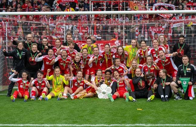 Fußball, Frauen, Saison 2024 2025, 2. Frauen-Bundesliga (26. Spieltag), 1. FC Union Berlin - FSV Gütersloh, anschließende Ehrung der Union-Frauen als Meisterinnen der 2. Bundesliga, im Bild: die Mannschaft mit der Meisterschale vor der Waldseite, 18.05. 2025, Copyright: xMatthiasxKochx