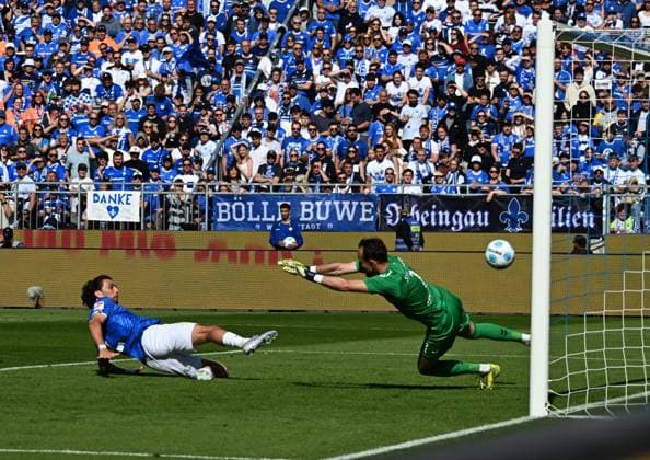 18.05.2025, xsltx, Fussball 2.Bundesliga, SV Darmstadt 98 - Jahn Regensburg v.l. Mit einer artistischen Grätsche spitzelt Fraser Hornby (SV Darmstadt 98) den Ball zum 2:1 ins Netz. re. Felix Gebhardt (SSV Jahn Regensburg) (DFL DFB REGULATIONS PROHIBIT ANY USE OF PHOTOGRAPHS as IMAGE SEQUENCES and or QUASI-VIDEO)