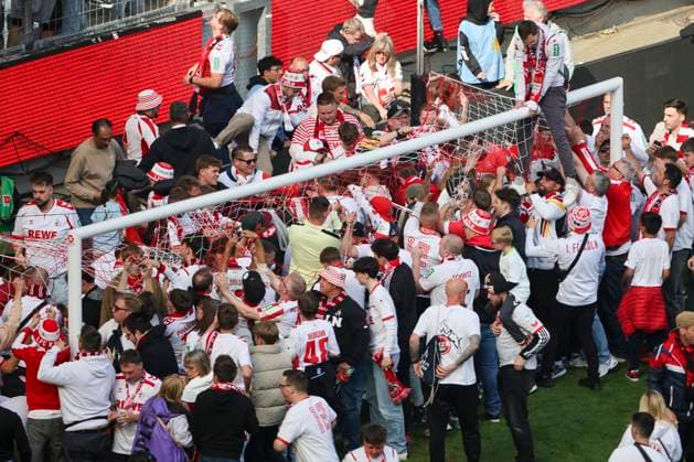 Fußball: 2. Bundesliga, 1. FC Köln - 1. FC Kaiserslautern, 34. Spieltag, RheinEnergieStadion. Fans des 1. FC Köln schneiden nach dem Schlusspfiff Teile des Tornetzes ab.