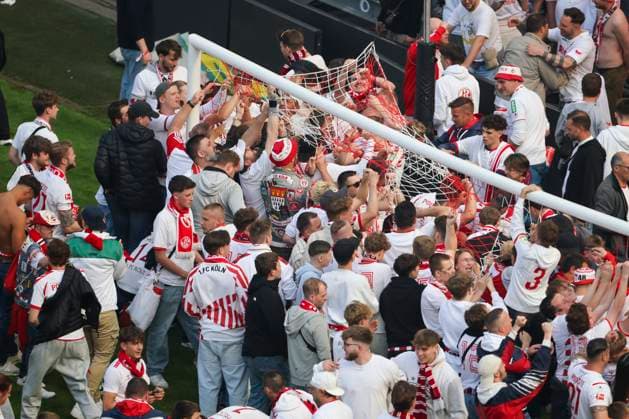 Fußball: 2. Bundesliga, 1. FC Köln - 1. FC Kaiserslautern, 34. Spieltag, RheinEnergieStadion. Fans des 1. FC Köln schneiden nach dem Schlusspfiff Teile des Tornetzes ab.