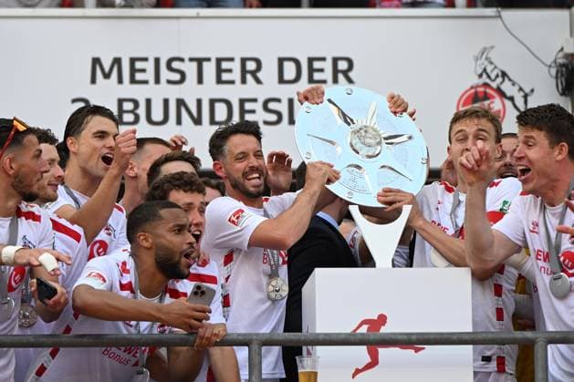 Mark Uth (1. FC Koeln) und Timo Huebers (1. FC Koeln) mit der Meisterschale der zweiten Bundesliga waehrend des Spiels der 2. Bundesliga zwischen 1. FC Köln und 1. FC Kaiserslautern im RheinEnergieStadion am 18. May 2025 in Köln, Deutschland. (Foto von Ralf Treese DeFodi Images) +++ Mark Uth (1. FC Koeln) und Timo Huebers (1. FC Koeln) the championship trophy of second Bundesliga during the 2. Bundesliga match between 1. FC Köln and 1. FC Kaiserslautern at RheinEnergieStadion on May 18, 2025 in Cologne, Germany. (Photo by Ralf Treese DeFodi Images) DFB DFL REGULATIONS PROHIBIT ANY USE OF PHOTOGRAPHS AS IMAGE SEQUENCES AND OR QUASI-VIDEO. (Photo by Ralf Treese DeFodi Images)