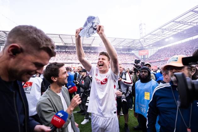 GER, 2. FBL, 1. FC Köln Koel vs 1.FC Kaiserslautern 18.05.2025, RheinEnergieStadion, Köln, GER, 2. FBL, 1. FC Köln Koel vs 1.FC Kaiserslautern im Bild: Dominique Heintz (1. FC Köln Koeln, 3) feiert mit Papier Meisterschale im Sky Interview