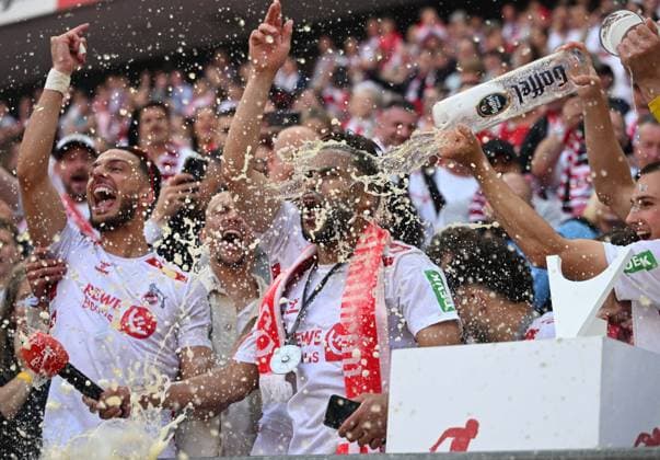 18.05.2025, xophax, Fussball 2.Bundesliga, 1.FC Koeln - 1.FC Kaiserslautern v.l. Meister der 2. Liga : 1.FC Köln Linton Maina bekommt Bierdusche Links Leart Pacarada Aufstiegsfinale 1.FC Köln gegen Kaiserslautern (DFL DFB REGULATIONS PROHIBIT ANY USE OF PHOTOGRAPHS as IMAGE SEQUENCES and or QUASI-VIDEO) Koeln
