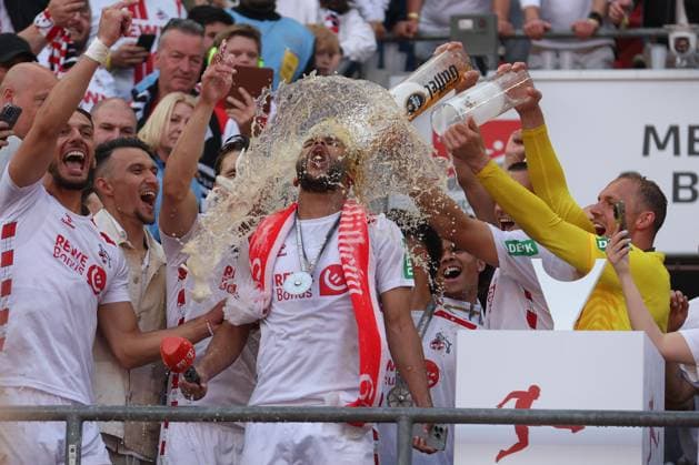 2. Bundesliga - 24 25 - 1. FC Köln - 1. FC Kaiserslautern am 18.05.2025 im RheinEnergieSTADION in Köln Jubel und Freude über die Meisterschaft bei der Mannschaft des 1 FC Köln, hier wird Linton Maina (Koeln 37) von einer Bierdusche von Torwart Marvin Schwäbe Schwaebe Schwabe (Koeln 1) überrascht
