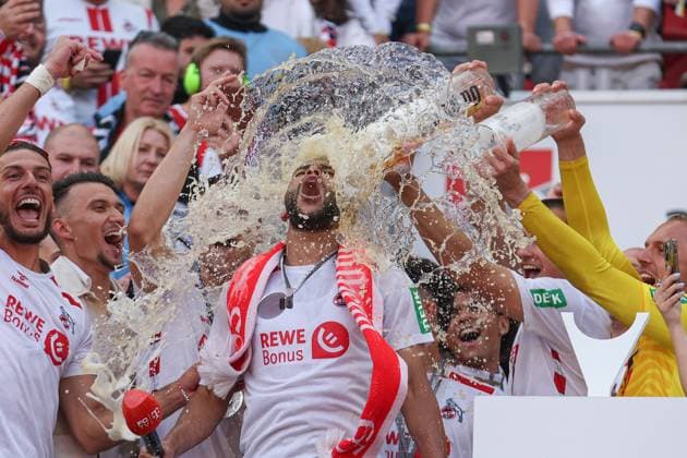 2. Bundesliga - 24 25 - 1. FC Köln - 1. FC Kaiserslautern am 18.05.2025 im RheinEnergieSTADION in Köln Jubel und Freude über die Meisterschaft bei der Mannschaft des 1 FC Köln, hier wird Linton Maina (Koeln 37) von einer Bierdusche von Torwart Marvin Schwäbe Schwaebe Schwabe (Koeln 1) überrascht