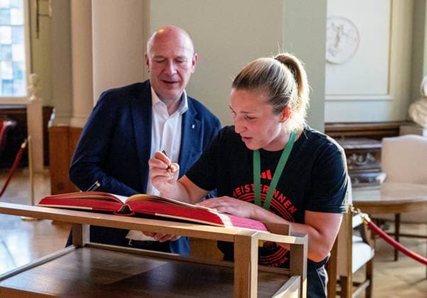 Fußball, Frauen, Saison 2024 2025, 2. Frauen-Bundesliga, 1. FC Union Berlin, die Aufsteigerinnen in die 1. Bundesliga werden im Roten Rathaus von Kai Wegner (Regierender Bürgermeister von Berlin) empfangen, im Bild: v. l. Berlins regierender Bürgermeister Kai Wegner, Dina Orschmann (1. FC Union) trägt sich in das Gästebuch der Stadt Berlin im Säulensaal ein, 20.05. 2025, Copyright: xMatthiasxKochx