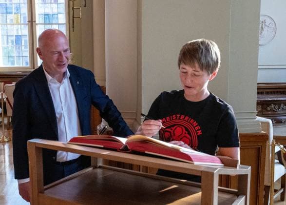 Fußball, Frauen, Saison 2024 2025, 2. Frauen-Bundesliga, 1. FC Union Berlin, die Aufsteigerinnen in die 1. Bundesliga werden im Roten Rathaus von Kai Wegner (Regierender Bürgermeister von Berlin) empfangen, im Bild: v. l. Berlins regierender Bürgermeister Kai Wegner, Trainerin Ailien Poese (1. FC Union) trägt sich ins Gästebuch der Stadt Berlin im Säulensaal ein, 20.05. 2025, Copyright: xMatthiasxKochx