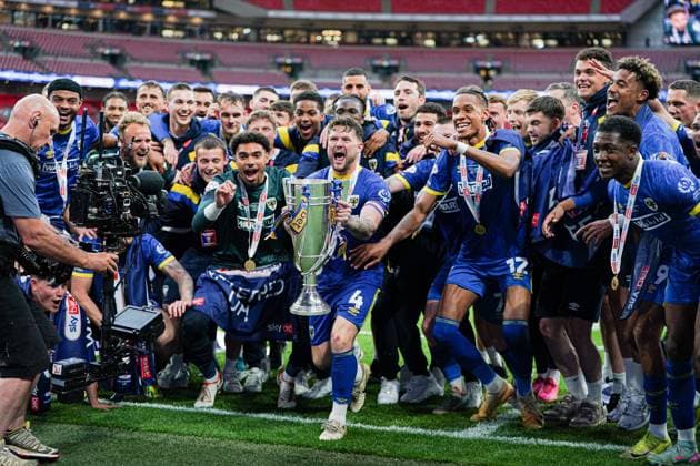 Sky Bet League 2 Playoff Final AFC Wimbledon v Walsall Wimbledon players lift league 2 play off trophy in front of supporters after the Sky Bet League 2 Playoff Final match AFC Wimbledon vs Walsall at Wembley Stadium, London, United Kingdom, 26th May 2025 (Photo by Harvey Murphy News Images) Copyright: xHarveyxMurphy NewsxImagesx