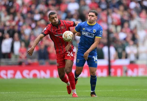 Football - 2024 2025 EFL Sky Bet League Two - Play-Offs - Final - AFC Wimbledon vs Walsall - Wembley Stadium - Monday 26th May 2025. Walsall s David Okagbue battles with AFC Wimbledon s Mathew Stevens. COLORSPORT Ashley Western 