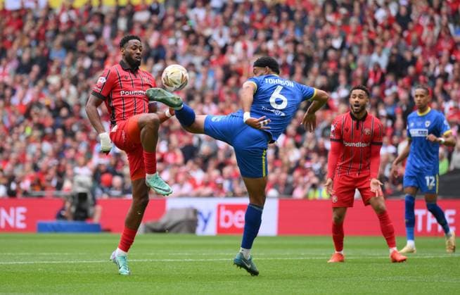 Football - 2024 2025 EFL Sky Bet League Two - Play-Offs - Final - AFC Wimbledon vs Walsall - Wembley Stadium - Monday 26th May 2025. Walsall s Jamille Matt is tackled by AFC Wimbledon s Ryan Johnson. COLORSPORT Ashley Western 