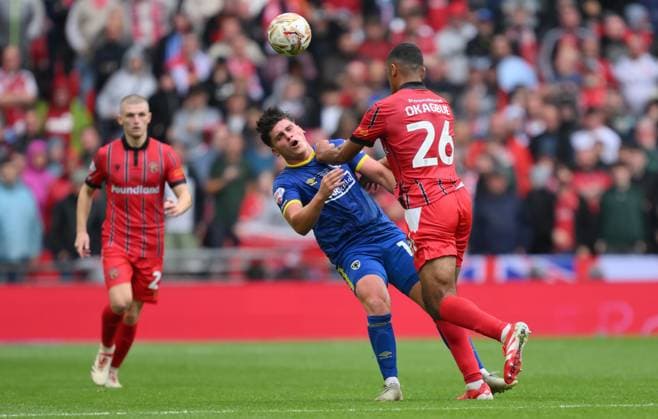 Football - 2024 2025 EFL Sky Bet League Two - Play-Offs - Final - AFC Wimbledon vs Walsall - Wembley Stadium - Monday 26th May 2025. AFC Wimbledon s Mathew Stevens is tackled by Walsall s David Okagbue. COLORSPORT Ashley Western 
