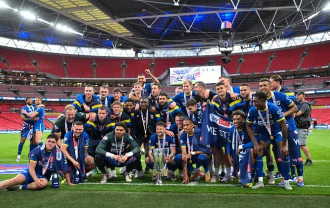 Football - 2024 2025 EFL Sky Bet League Two - Play-Offs - Final - AFC Wimbledon vs Walsall - Wembley Stadium - Monday 26th May 2025. AFC Wimbledon s Jake Reeves and the team with the trophy after their promotion to League One. COLORSPORT Ashley Western 
