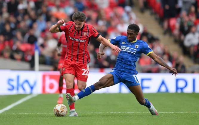 Football - 2024 2025 EFL Sky Bet League Two - Play-Offs - Final - AFC Wimbledon vs Walsall - Wembley Stadium - Monday 26th May 2025. Walsall s Jamie Jellis is tackled by AFC Wimbledon s Josh Neufville. COLORSPORT Ashley Western 
