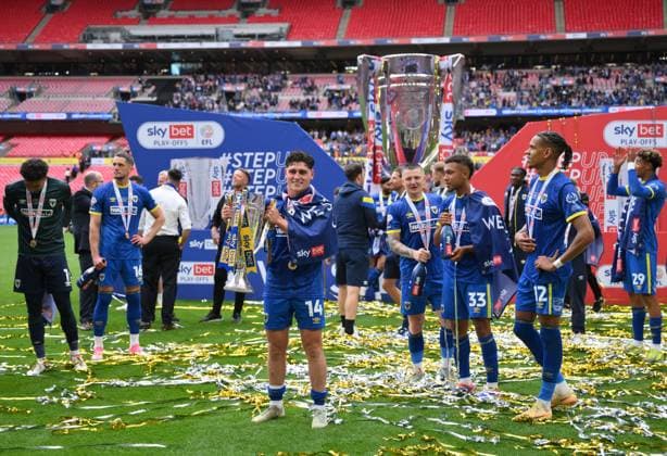 Football - 2024 2025 EFL Sky Bet League Two - Play-Offs - Final - AFC Wimbledon vs Walsall - Wembley Stadium - Monday 26th May 2025. AFC Wimbledon s Mathew Stevens with the trophy after their promotion to League One. COLORSPORT Ashley Western 