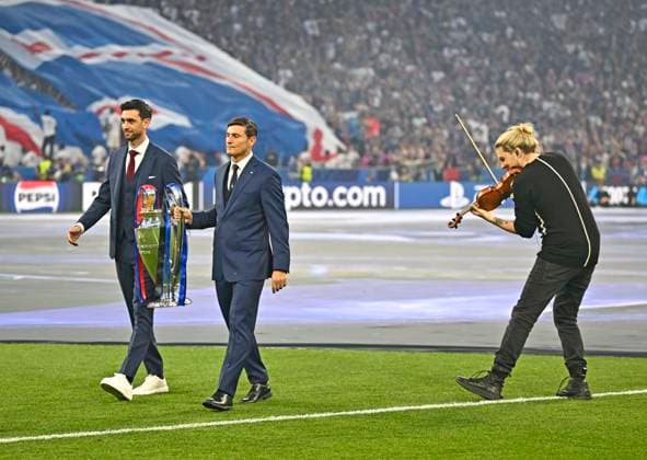 31.05.2025, Fussball UEFA Championsleague Finale 2025: Paris St. Germain - Inter Mailand, in der Allianz-Arena München. Javier Pastore und Javier Zanetti (Italien) tragen die Trophäe ins Stadion waährend David Garret aufspielt
