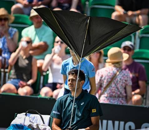 Sport Bilder des Tages 19th June 2025; Lexus Nottingham Tennis Centre, Nottingham, England; Lexus Nottingham Open, Day 4; Emilio Nava (USA) has an umbrella malfunction after winning the first set against Colton Smith (USA)  ActionPlus12802512 GodfreyxPitt