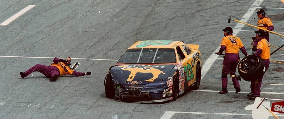 Florida News - February 15, 1997 SP 445DAYT - - DELIVER TO: Sports - - 2 16 97 - - Daytona - - STORY SUMMARY: - - CAPTION INFO: The Jack Man for Jimmy Spencer s car the 23 Joe Camel car, gets knocked over the hood and lands on the driving lane of the pits, as the first caution of the race took place, by ab accident that involved the 23 car. he was able to recover and change the tire. LIB NOTE: Daytona 500. - - Times Photo by: Ricardo Ferro - - Story By: Korth - - SCANNED BY: Rf - - RUN DATE: 2 17 1997 Copyright: xStxPetersburgxTimesx