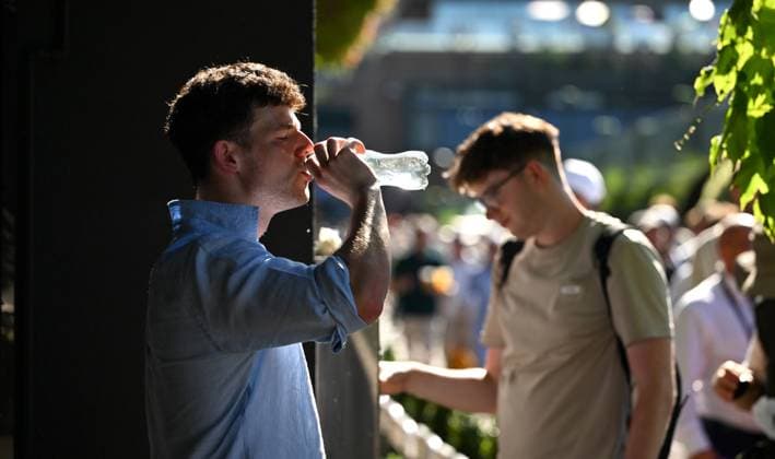 (250701) -- LONDON, July 1, 2025 -- A man drinks water after refilling his water bottle on the opening day of the Wimbledon Championships in London, Britain, June 30, 2025. Tennis fans faced the hottest start to Wimbledon on record on Monday as temperature soared to 32 degrees Celsius. ) BRITAIN-LONDON-TENNIS-WIMBLEDON-OPENING DAY-WEATHER LixYing 