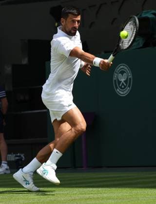 Serbian Novak Djokovic plays a backhand in his second round match against Great Britain s Dan Evans on day four of the 2025 Wimbledon Championships in London on Thurs, June 03, 2025.  LON2025070311 HUGOxPHILPOTT