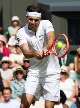 American Taylor Fritz plays a backhand in his third round match against Spain s Alejandro Davidovich Fokina on day five of the 2025 Wimbledon Championships in London on Friday, July 04, 2025.  LON2025070449 HUGOxPHILPOTT