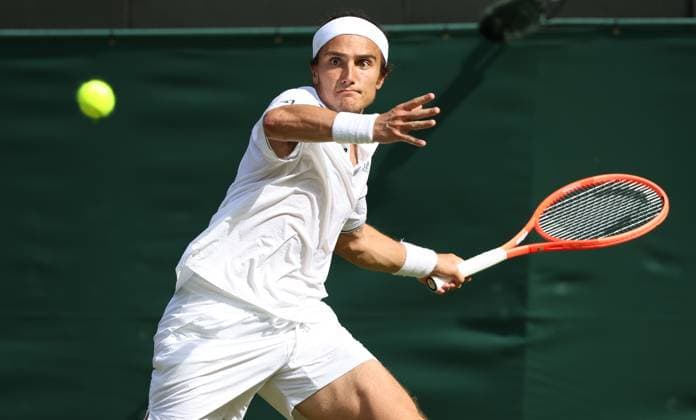 Italian Mattia Bellucci plays a forehand in his third round match against Great Britain s Cameron Norrie on day five of the 2025 Wimbledon Championships in London on Friday, July 04, 2025.  LON2025070453 HUGOxPHILPOTT
