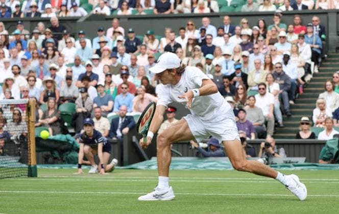 Australia s Alex De Minaur plays a forehand in his fourth round match against Serbian Novak Djokovic on day eight of the 2025 Wimbledon Championships in London on Monday, July 07, 2025.  LON2025070729 HUGOxPHILPOTT