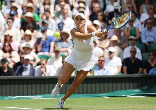 Switzerland s Belinda Bencic plays a backhand in her Quarter-Final match against Mirra Andreeva on day ten of the 2025 Wimbledon Championships in London on Wednesday, July 09, 2025.  LON2025070927 HUGOxPHILPOTT