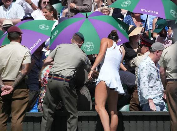 Tennis - 2025 Wimbledon Championships - Ladies singles Semi Final. Aryna Sabalenka v Amanda Anisimova All England Lawn Tennis & Croquet Club - Thursday 10th July 2025 Aryna Sabalenka runs over with a bottle of water for a spectator who has passed out with heat stroke 