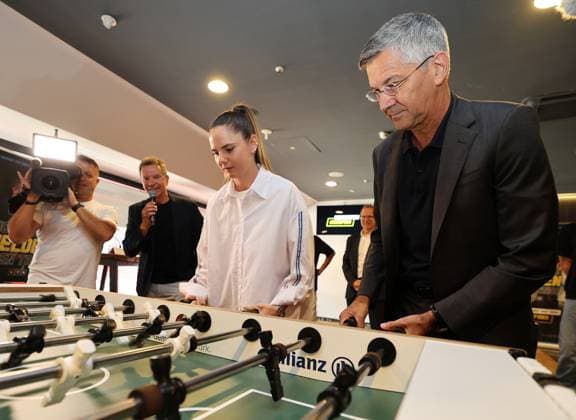 Herbert Hainer (Präsident des FC Bayern München) und Sarah Zadrazil (FC Bayern München) spielen gemeinsam Tischfußball, Tischkicker; Zwischenbilanz-Pressekonferenz zur Kampagne für mehr Respekt für Sicherheits- und Einsatzkräfte gezogen, die im Mai 2023 unter dem Motto Nicht alle Helden tragen Trikots. EUREFANS: Der sagt Danke! vom Bayerischen Innenministerium gestartet worden war und die der Bayerische Fußball-Verband (BFV) mitkonzipiert hat sowie unterstützt. Allianz Arena, München, 16.07.2025 *** Herbert Hainer President of FC Bayern Munich and Sarah Zadrazil FC Bayern Munich play table soccer together, table football Interim press conference on the campaign for more respect for security and emergency services, which was launched in May 2023 under the motto Not all heroes wear jerseys EUREFANS Der Sport sagt Danke by the Bavarian Ministry of the Interior and which the Bavarian Football Association BFV helped to design and support Allianz Arena, Munich, 16 07 2025