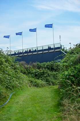 30th July 2025; Royal Porthcawl Golf Club, Porthcawl, Wales; AIG Womens Open Golf, Practice Day; Grandstand overlooking 1st tee box and 18th green with AIG flags flying in the wind  AledxHopkins