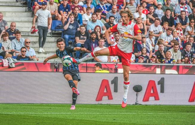 Fussball Österreich, UEFA Champions League 2025 2026, 3. Qualifikationsrunde - Red Bull Salzburg vs. Club Brügge - Red Bull Arena (Salzburg, Wals-Siezenheim, Österreich): Hugo Vetlesen (Club Brugge KV) mit Maurits Kjaergaard (Red Bull Salzburg) Copyright: xLukasxBierederx