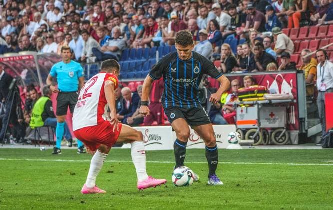 Fussball Österreich, UEFA Champions League 2025 2026, 3. Qualifikationsrunde - Red Bull Salzburg vs. Club Brügge - Red Bull Arena (Salzburg, Wals-Siezenheim, Österreich): Christos Tzolis (Club Brugge KV) mit Stefan Lainer (Reb Bull Salzburg) Copyright: xLukasxBierederx