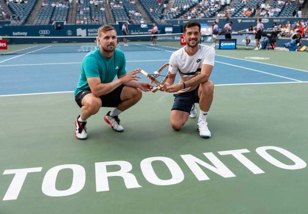 (250808) -- TORONTO, Aug. 8, 2025 -- Winners Julian Cash (R) Lloyd Glasspool pose with the trophy during the awarding ceremony after the men s doubles final match between Joe Salisbury Neal Skupski of Britain and Julian Cash Lloyd Glasspool of Britain at the 2025 National Bank Open tennis tournament in Toronto, Canada, on Aug. 7, 2025. (Photo by Xinhua) (SP)CANADA-TORONTO-TENNIS-NATIONAL BANK OPEN-MEN S DOUBLES FINAL ZouxZeng 