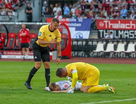 Clemens Riedel 38 (SV Darmstadt 98) liegt verletzt am Boden, Referee Schiedsrichter Florian Lechner und Marcel Schuhen 1 (SV Darmstadt 98) kuemmern sich um ihn, 1. FC Nuernberg vs. SV Darmstadt 98, DFL, 2. Bundesliga, Saison 2025 2026, 2. Spieltag, Hinrunde, 08.08.2025 DFB regulations prohibit any use of photographs as image sequences and or quasi-video Nuernberg Bayern Deutschland