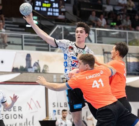08.08.2025 Handball Sporthalle Schwaz Ost, Osthalle, Tirol, Österreich Silberregion Karwendel Cup Halbfinale Sparkasse Schwaz Handball Tirol (weiß) - ThSV Eisenach (orange) Bild: 32 Tobias Grothues (Schwaz), 41 Vukasin Antonijevic (Eisenach), 27 Philipp Meyer (Eisenach)