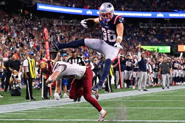 Aug 8, 2025; Foxborough, MA, USA; New England Patriots wide receiver Efton Chism III (86) leapfrogs over Washington Commanders safety Ben Nikkel (48) for a touchdown during the second half at Gillette Stadium. CSM Foxborough USA - ZUMAc04_ 20250808_faf_c04_039 Copyright: xEricxCanhax