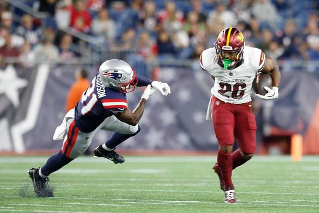 FOXBOROUGH, MA - AUGUST 08: Washington Commanders running back Jeremy McNichols (26) avoids a tackle by New England Patriots safety Craig Woodson (31) during the NFL, American Football Herren, USA preseason game between Washington Commanders and New England Patriots on August 8, 2025, at Gillette Stadium in Foxborough, MA. (Photo by M. Anthony Nesmith Icon Sportswire) NFL: AUG 08 Preseason Commanders at Patriots EDITORIAL USE ONLY Icon25080822