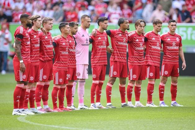 09.08.2025, Fußball, Fortuna Düsseldorf - Hannover 96, 2. Fußball Bundesliga, Merkur Spiel-Arena, Saison 2025 2026: Die Startelf der Fortuna ARm in Arm bei der Schweigeminute vor dem Spiel DFB regulations prohibit any use of photographs as image sequences and or quasi-video. Nordrhein-Westfalen Deutschland