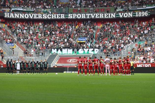 Mannschaften von Hannover 96 und Fortuna Duesseldorf bei der Schweigeminute zu Ehren von Frank Mill waehrend des spiels der 2. Bundesliga zwischen Fortuna Dusseldorf und Hannover 96, Merkur Spiel-Arena am 09. August 2025 in Gelsenkirchen, Deutschland. (Foto von Oliver Kaelke DeFodi Images) +++ Teams from Hannover 96 and Fortuna Duesseldorf during the minute of silence in honor of Frank Mill during the 2. Bundesliga match between Fortuna Düsseldorf and Hannover 96 at Merkur Spiel-Arena on August 9, 2025 in Gelsenkirchen, Germany. (Photo by Oliver Kaelke DeFodi Images) DFB DFL REGULATIONS PROHIBIT ANY USE OF PHOTOGRAPHS AS IMAGE SEQUENCES AND OR QUASI-VIDEO. (Photo by Oliver Kaelke DeFodi Images)