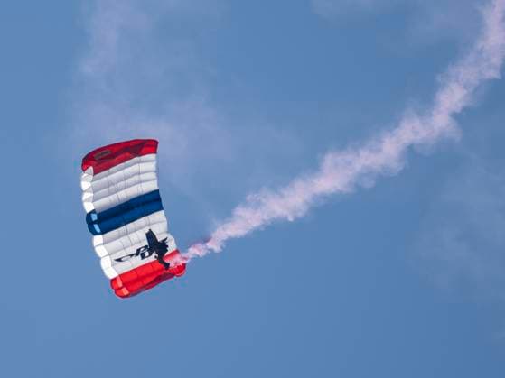 BOLINGBROOK, IL - AUGUST 09: A parachuter flys over the course to start day two of LIV Golf Chicago on Saturday, August 09, 2025 at Bolingbrook Golf Club in Bolingbrook, IL. (Photo by Joseph Weiser Icon Sportswire) GOLF: AUG 09 LIV Golf Chicago EDITORIAL USE ONLY Icon250809008